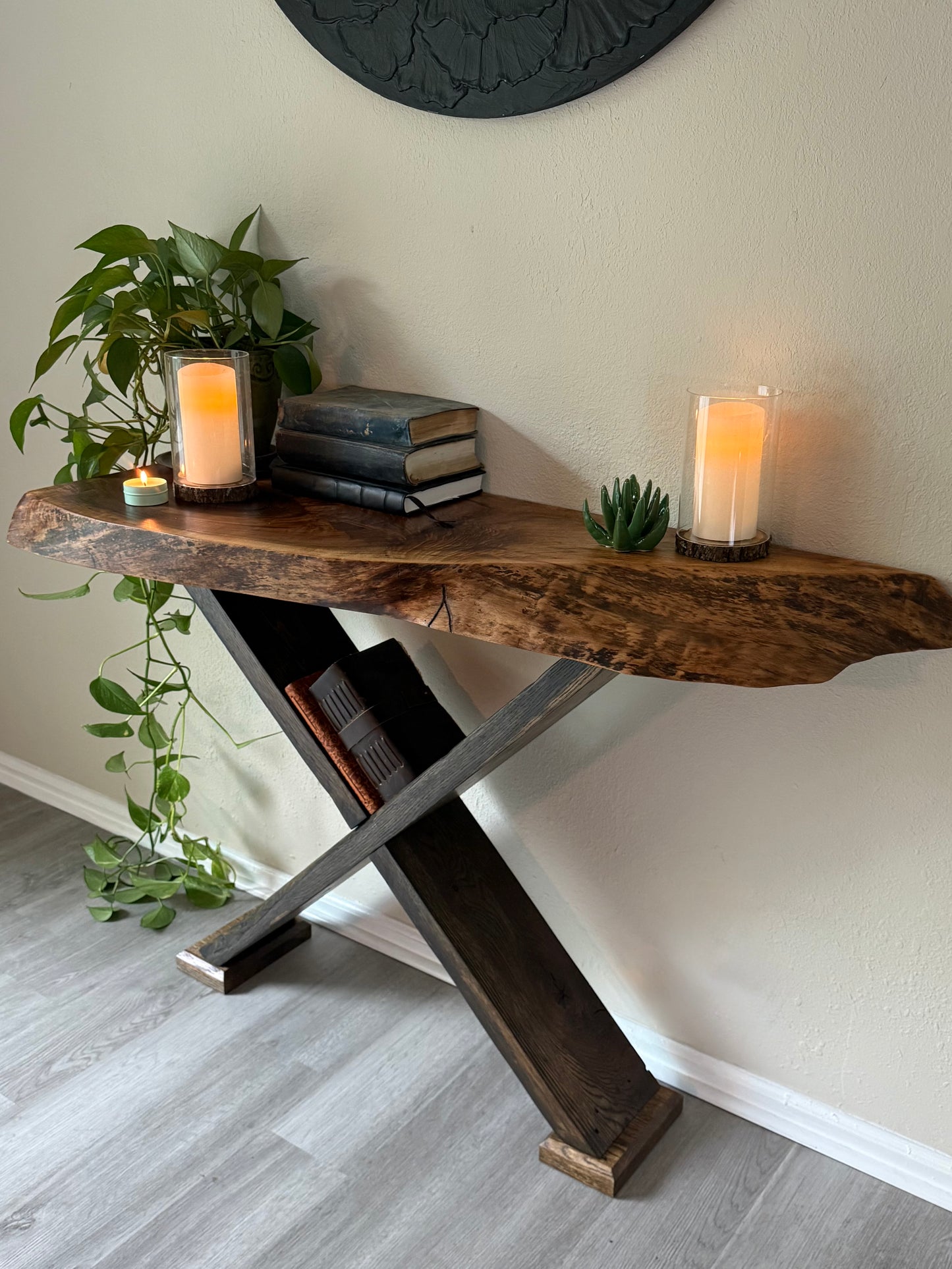 live edge wood console table styled with trailing greenery, vintage books and candles