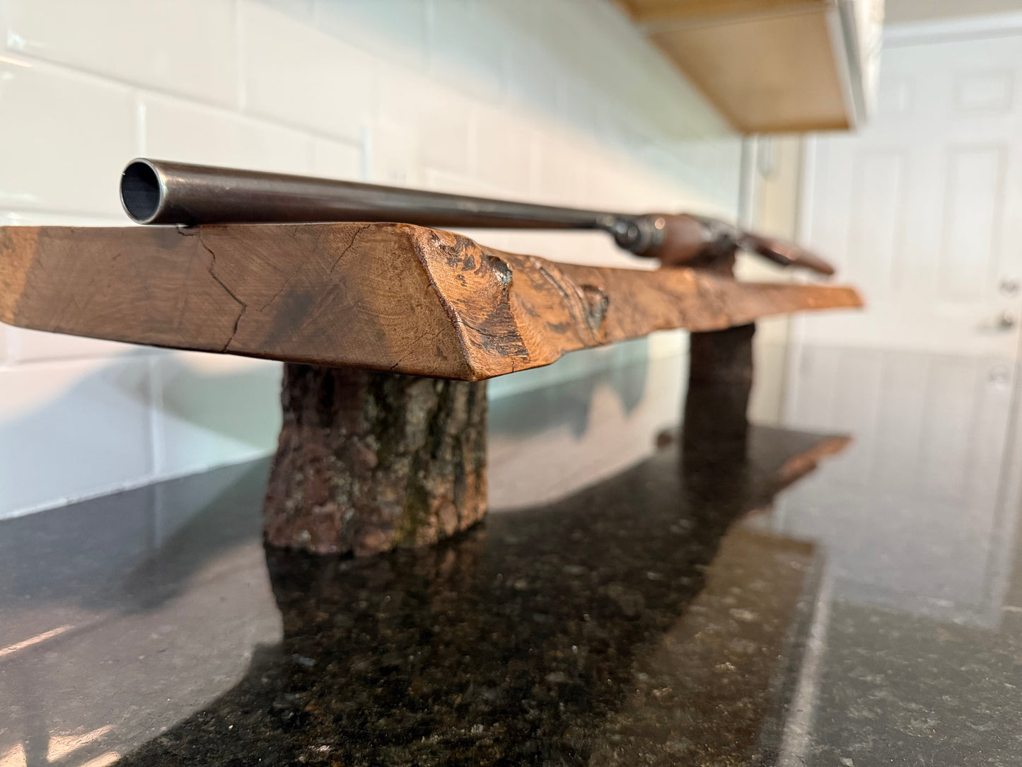 display rifle on live edge shelf with natural bark legs