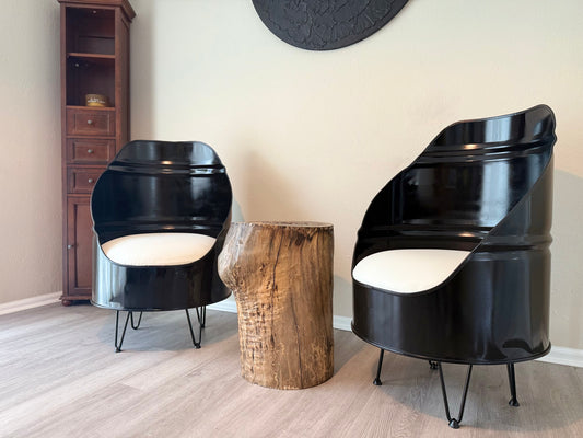 pair of glossy black industrial chairs with white cushions and hairpin legs, styled with a live edge stump table in a modern room