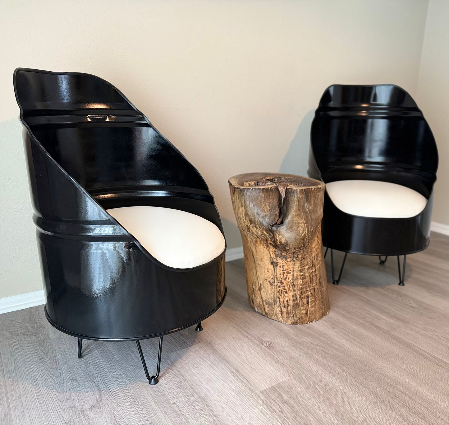 side view of handcrafted industrial steel chairs with white cushions and hairpin legs, styled with a live edge stump table in a modern room