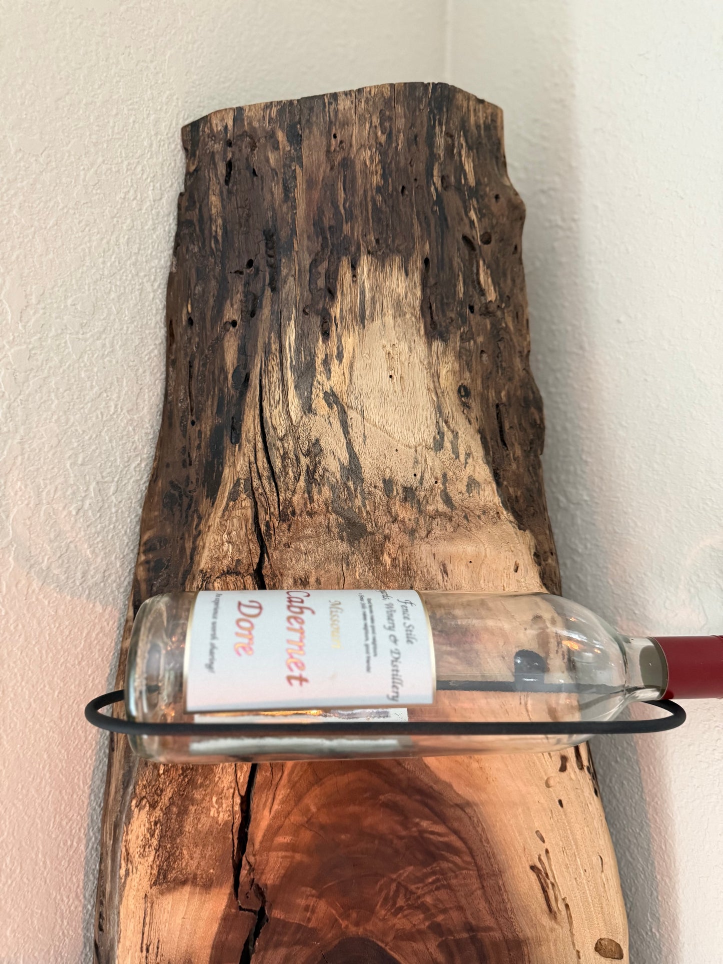 Top detail of rustic wine rack showing weathered natural edge.