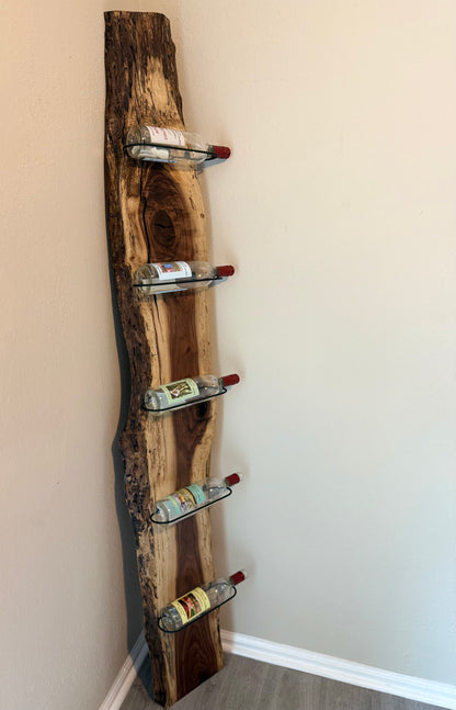 Rustic wall-mounted wine rack holding five wine bottles at an angle.