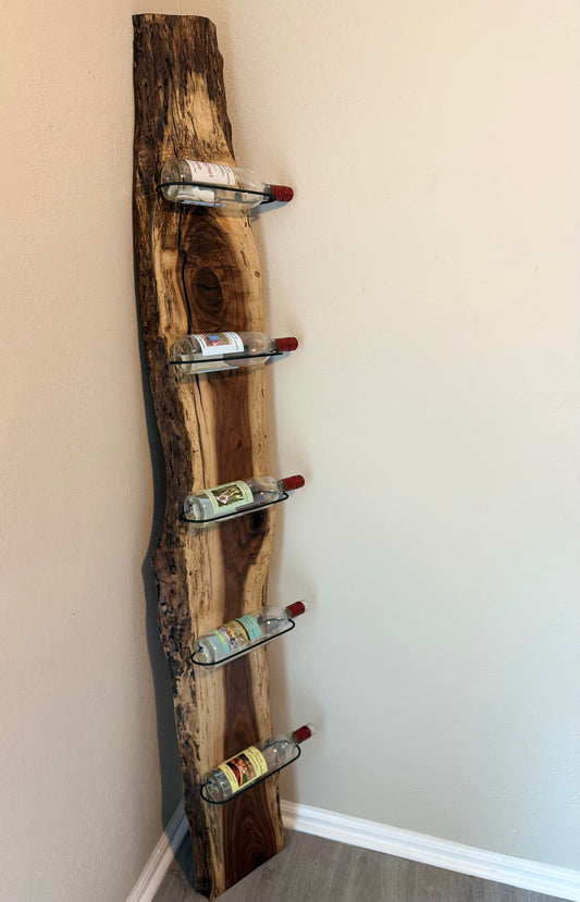 Rustic wall-mounted wine rack holding five wine bottles at an angle.